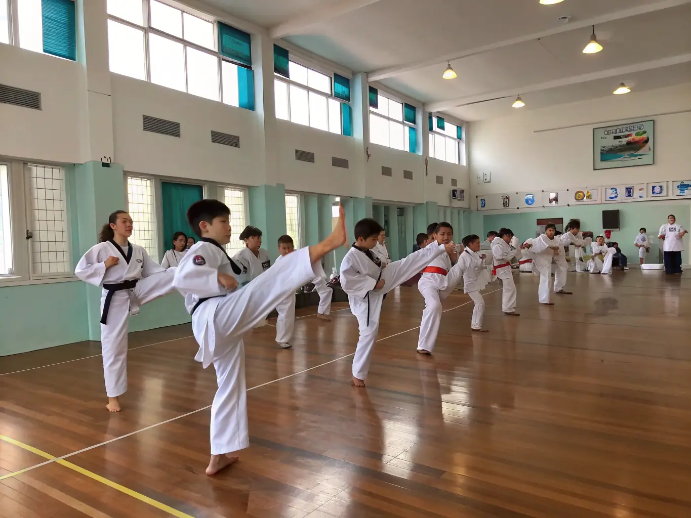 A diverse group of students of different ages and backgrounds laughing and interacting during a Taekwondo class, highlighting the social and community aspects of the club.